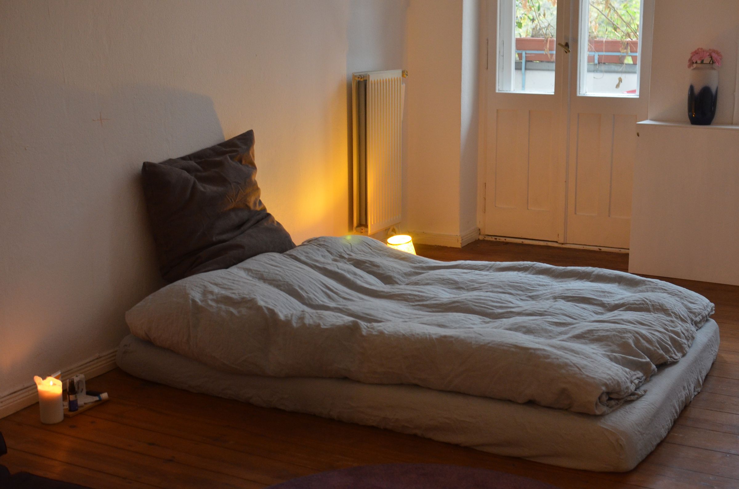 Warm, softly lit room with a low bed and layered natural linens